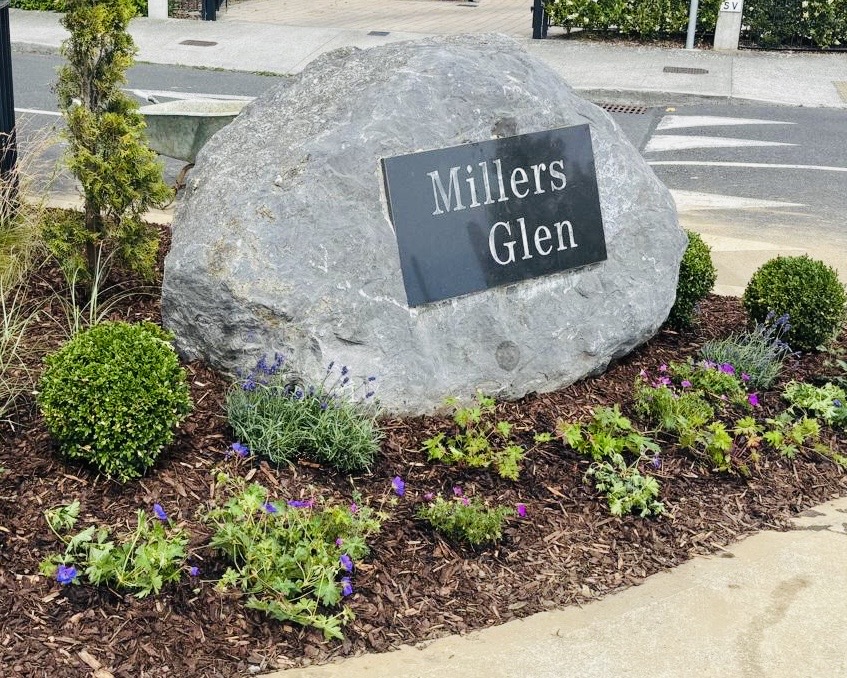 Millers Glen stone entrance sign surrounded by fresh planting